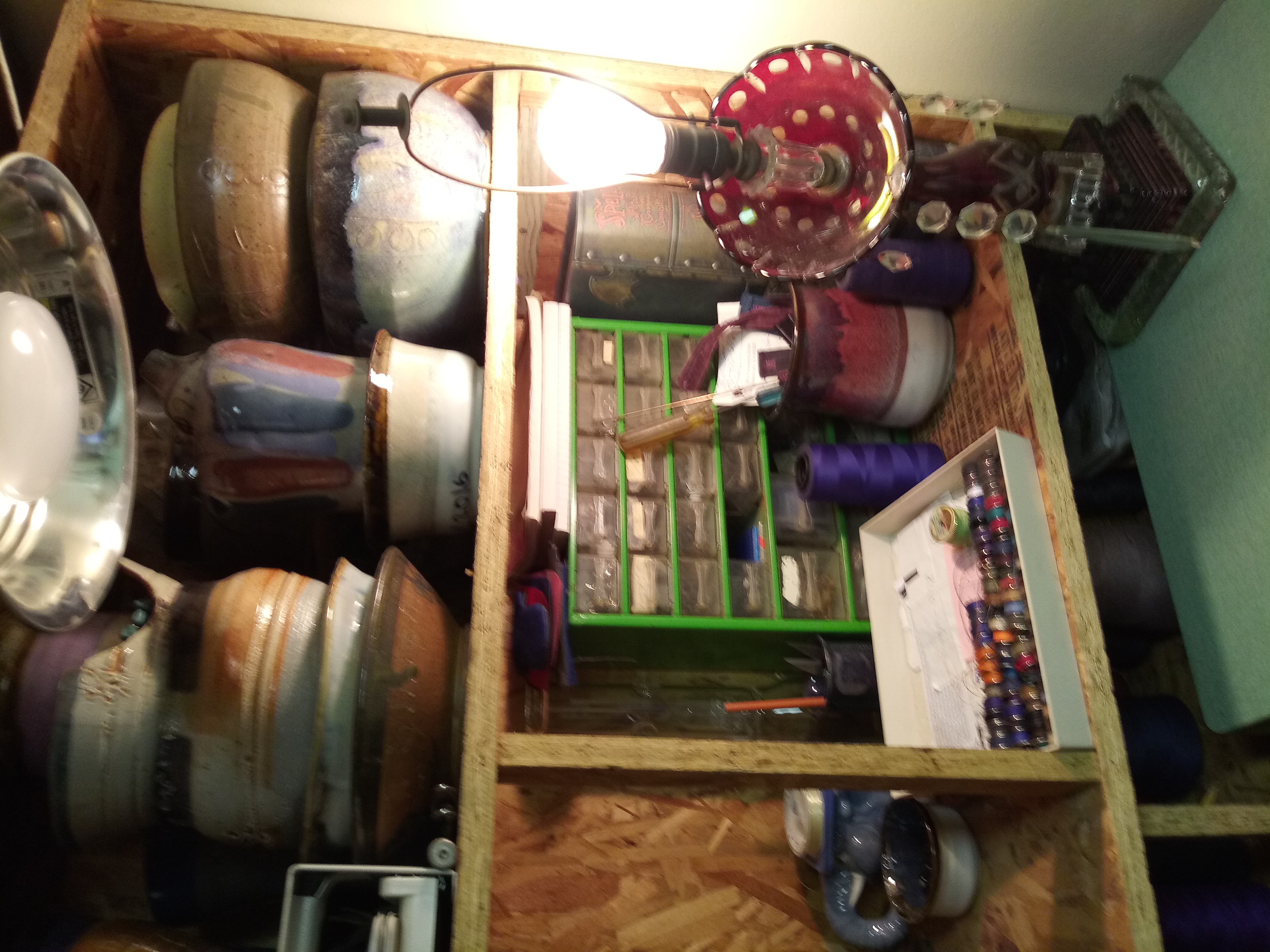 Organized bobbins on shelf with pottery